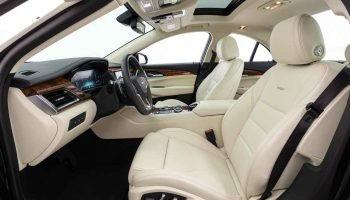 half white Cadillac CTS front seates interior 2026 Chauffeur Car Hire Dubai